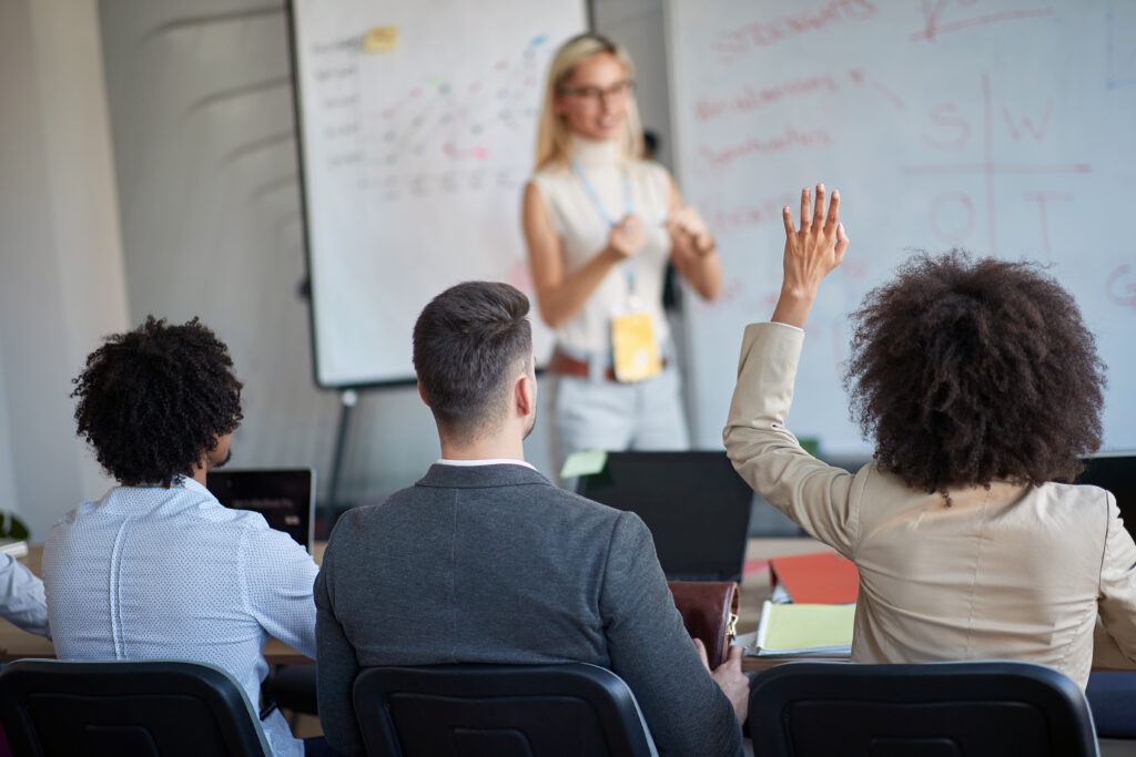 Young Caucasian blonde female manager teaching colleagues. Business lecture, presentation