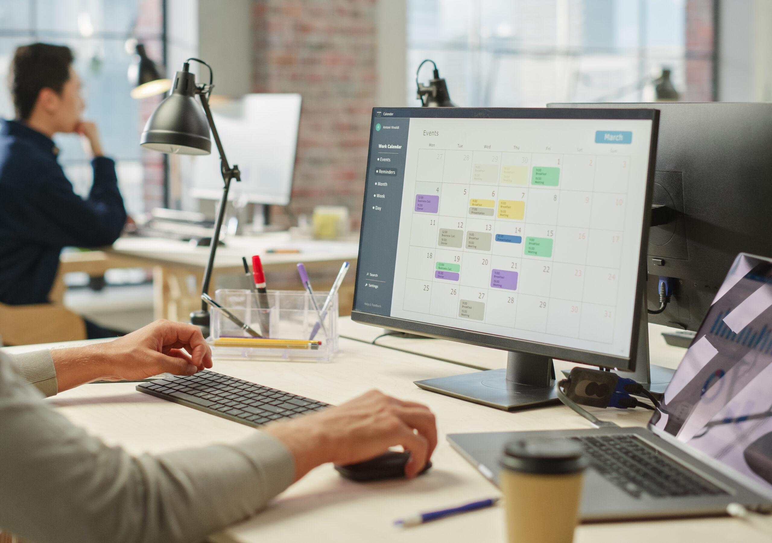 A business professional looking at a digital calendar on a computer.