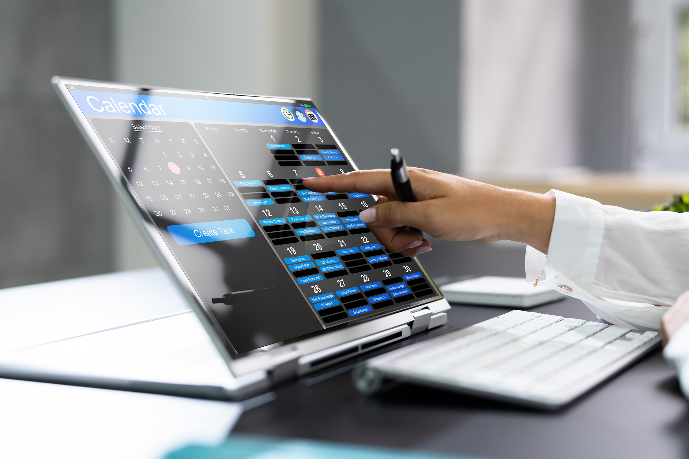 A business professional looking at a calendar on a laptop